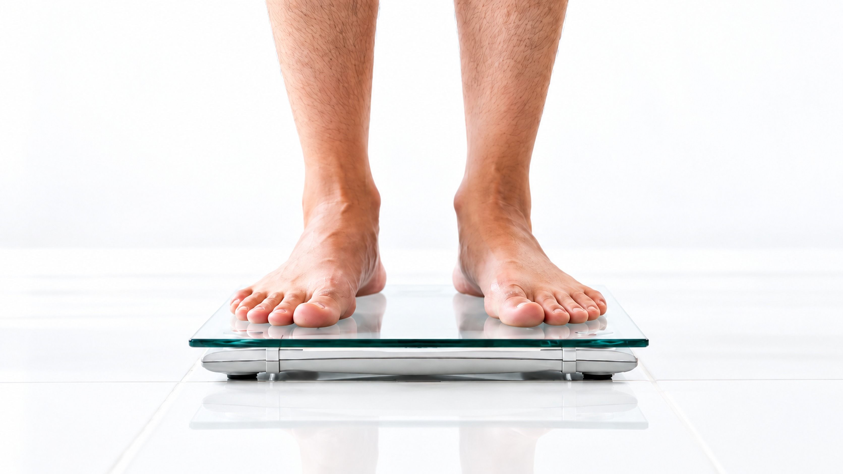 Bare feet stepping onto a glass bathroom scale